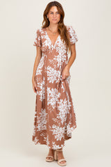 woman wearing a brown floral maxi dress with a deep v-neck and short puff sleeves
