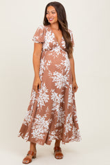 woman wearing a brown floral maternity maxi dress with a deep v-neck and short sleeves, showing her baby bump
