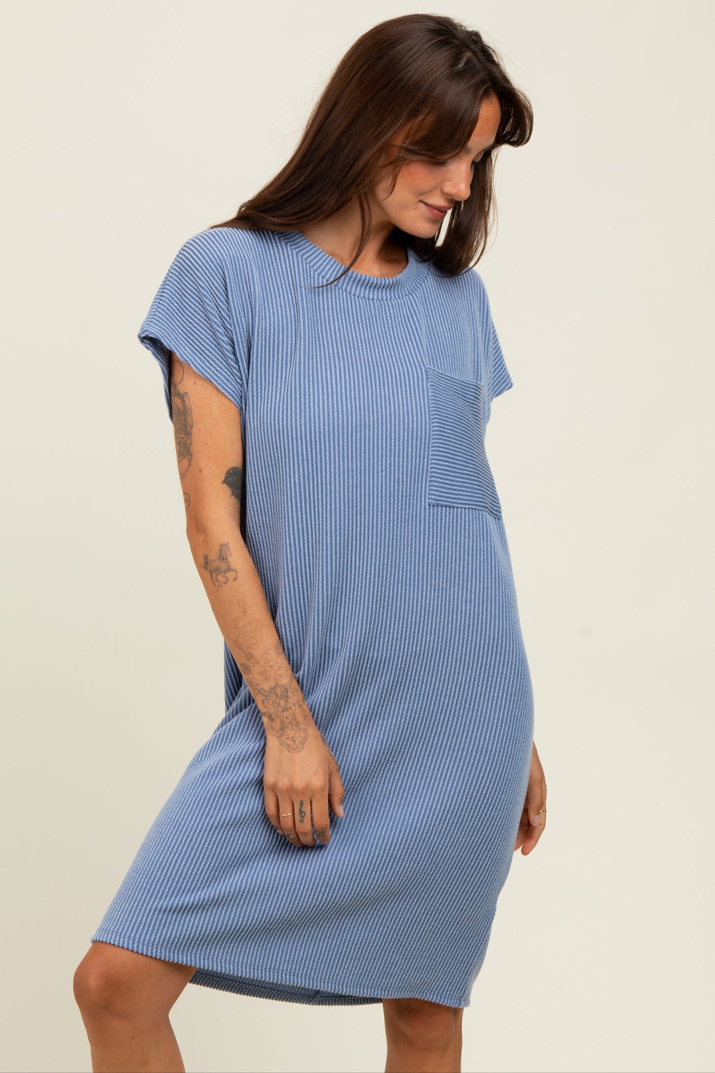woman wearing a blue striped short sleeve dress with a pocket and a relaxed fit