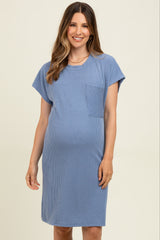 woman wearing a striped blue maternity dress with short sleeves and a pocket, showing her baby bump