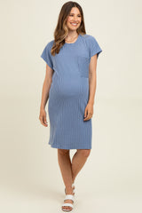 woman wearing a blue striped maternity dress with short sleeves and a chest pocket, displaying her baby bump