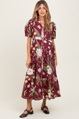 woman wearing a burgundy floral maternity dress with puff sleeves and a button-down front