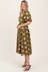 woman wearing an olive green floral midi dress with puff sleeves and a square neckline, standing sideways