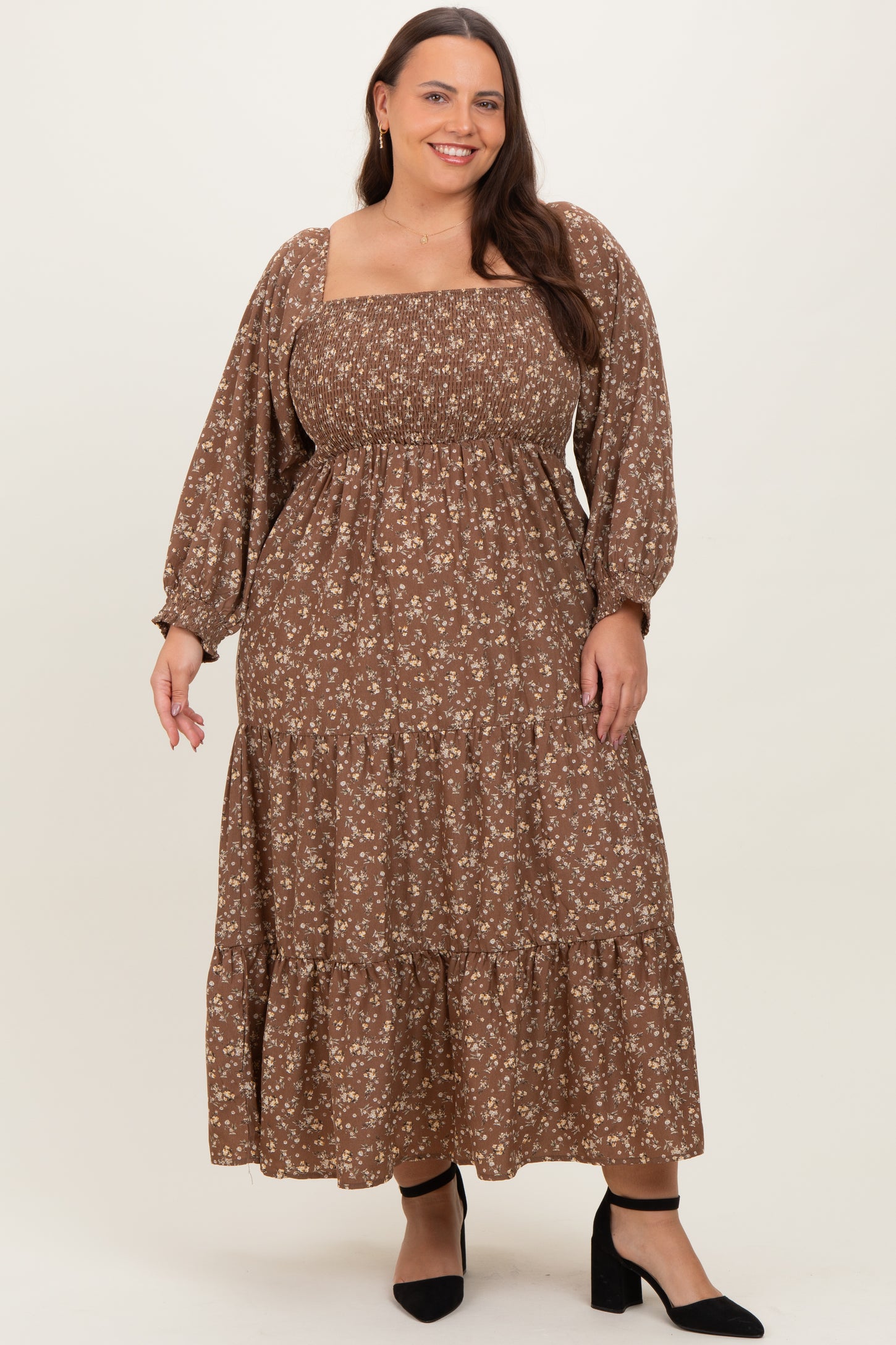 woman wearing a brown floral plus size maxi dress with smocked bodice and long puff sleeves