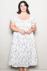 woman wearing a white floral plus-size tea dress with short puff sleeves and a square neckline
