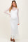 woman wearing a white lace maternity dress with long sleeves and a visible baby bump