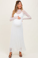 woman wearing a white lace long sleeve maternity dress and holding her baby bump