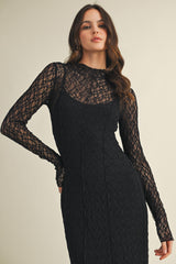 woman wearing a black lace long sleeve dress with a fitted silhouette and high neckline