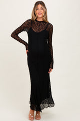 woman wearing a black lace maternity dress with long sleeves and a fitted silhouette, showcasing her baby bump