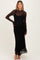 woman wearing a black lace maternity dress with long sleeves and a fitted silhouette, showcasing her baby bump