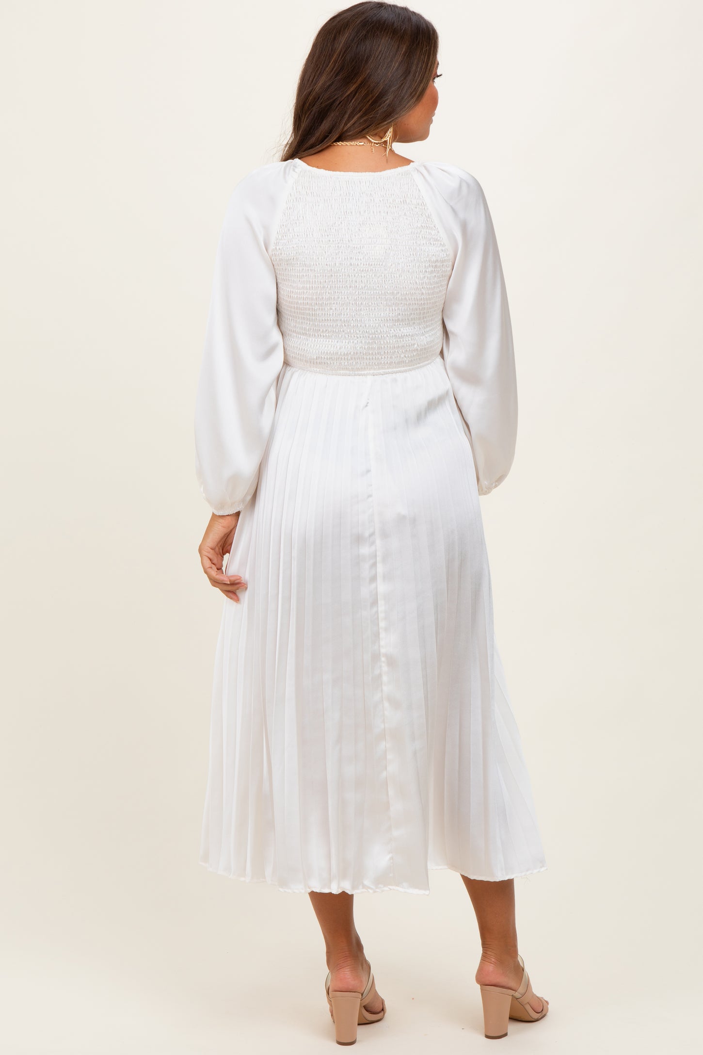 woman wearing a white maternity midi dress with smocked bodice and pleated skirt, seen from the back