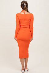 woman wearing a bright orange ribbed maternity dress with long sleeves and a tie detail at the back