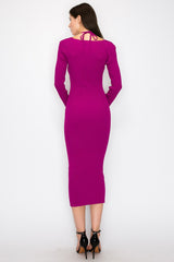 woman wearing a fitted hot pink long sleeve dress with a tie detail at the back