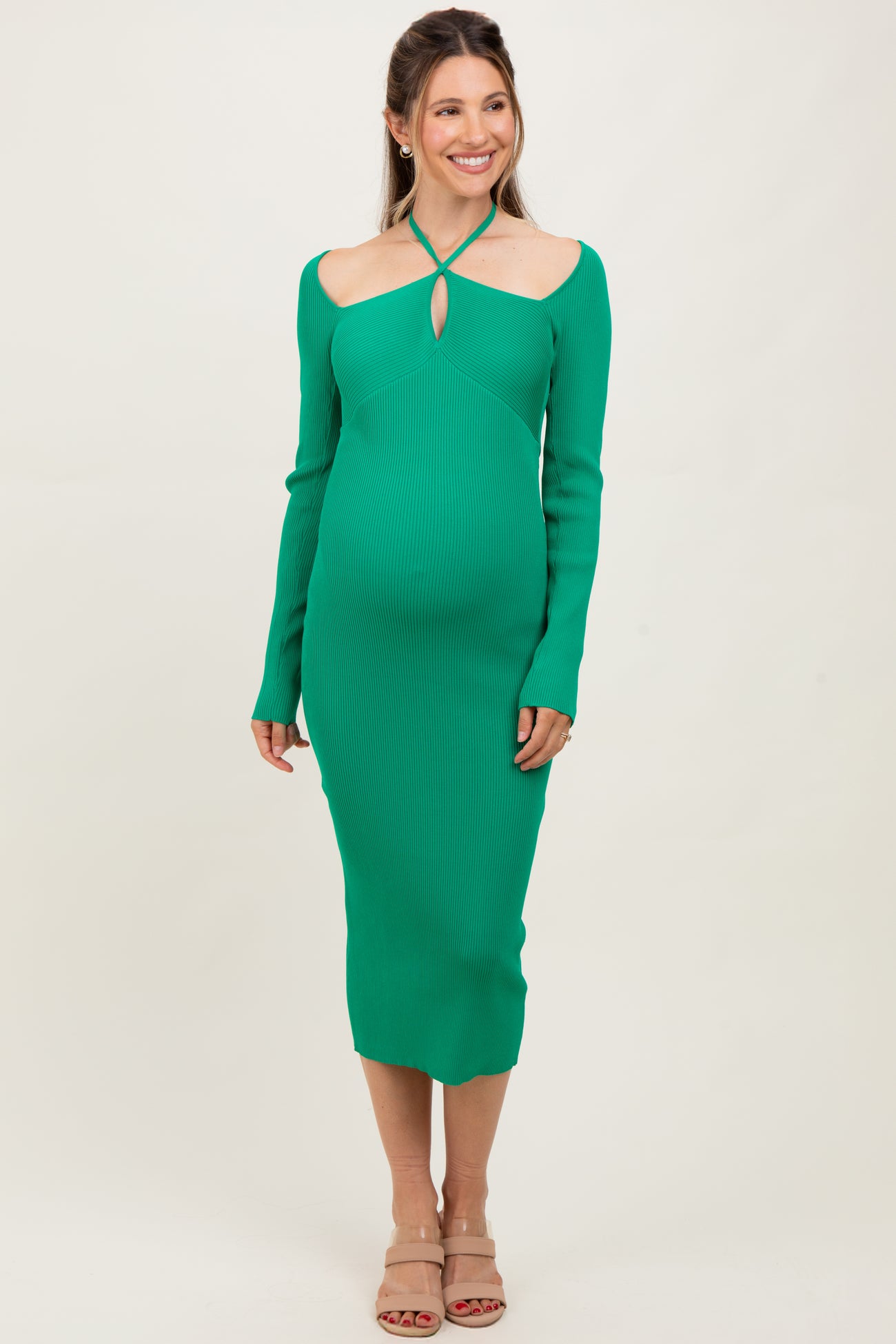 woman wearing a green ribbed long sleeve maternity dress with a keyhole cutout and a visible baby bump