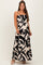 woman wearing a black and white floral print maternity maxi dress with adjustable straps and a ruffled hem, showing baby bump