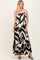 woman wearing a black and cream maxi dress with abstract print and tiered hem, standing and smiling