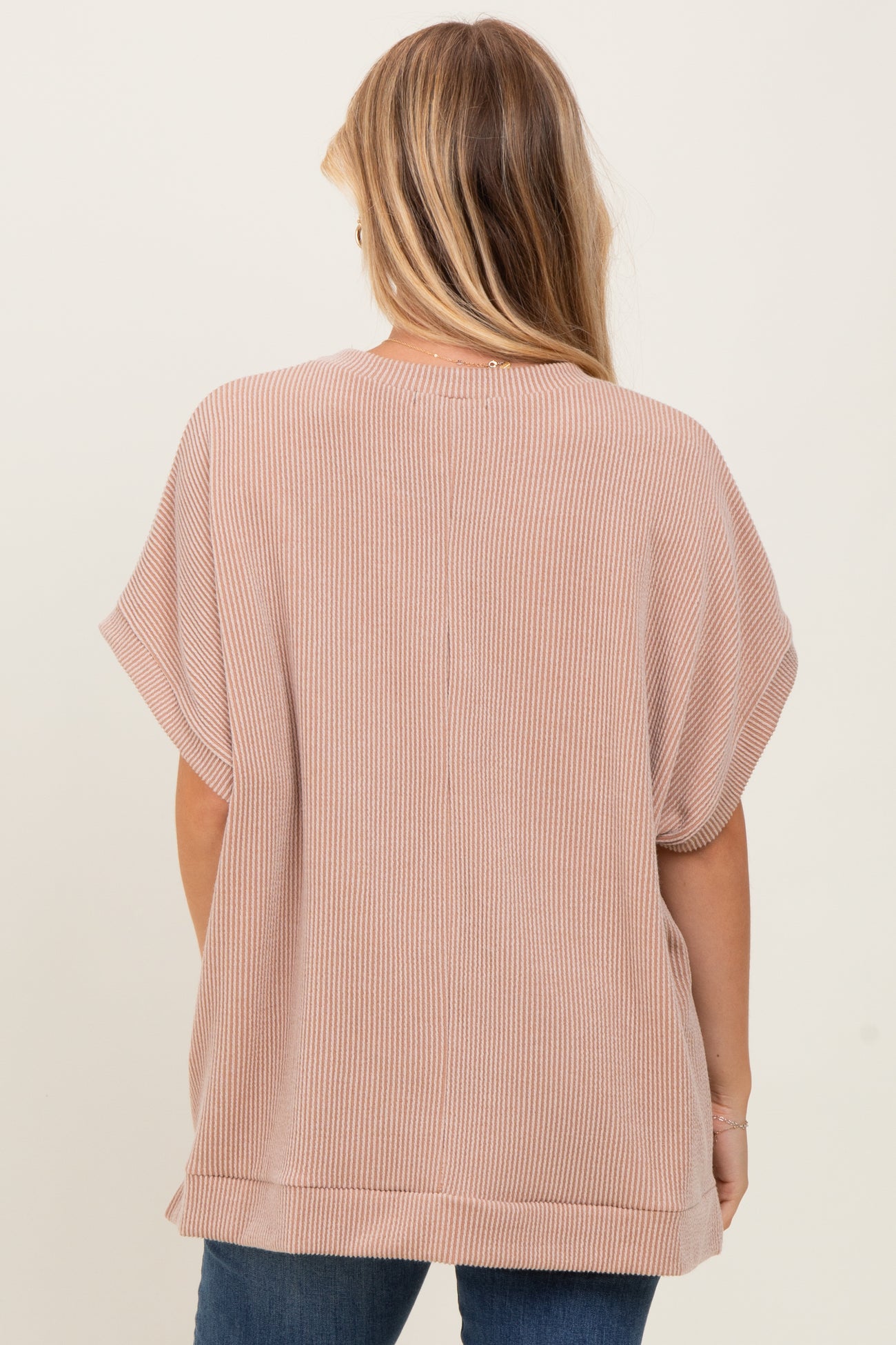 woman wearing a beige striped short sleeve top, showcasing a relaxed fit and back view