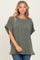 woman wearing a relaxed fit olive green ribbed knit top with short sleeves and side slits, paired with jeans