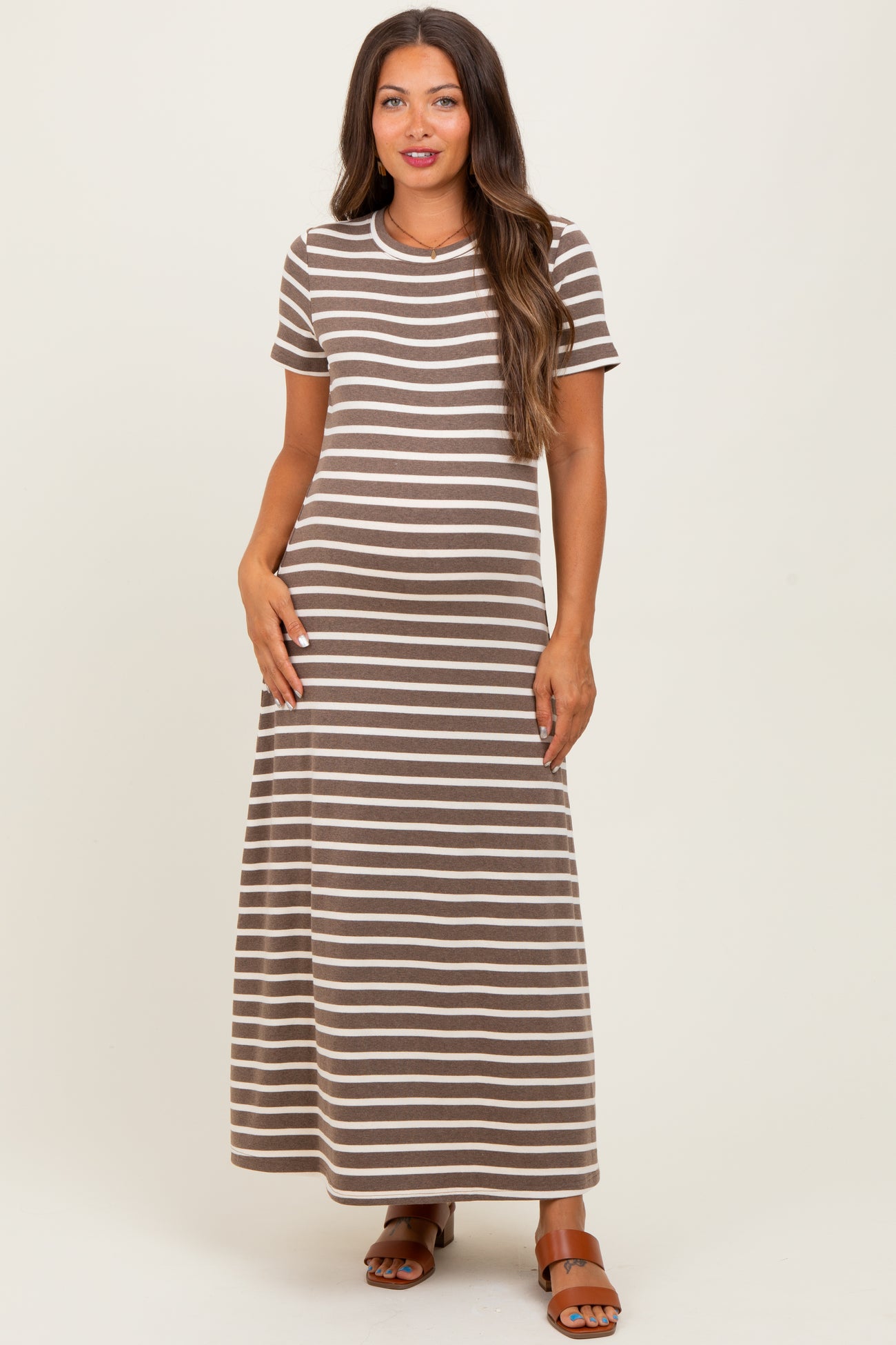 woman wearing a brown and cream striped maternity maxi dress with short sleeves