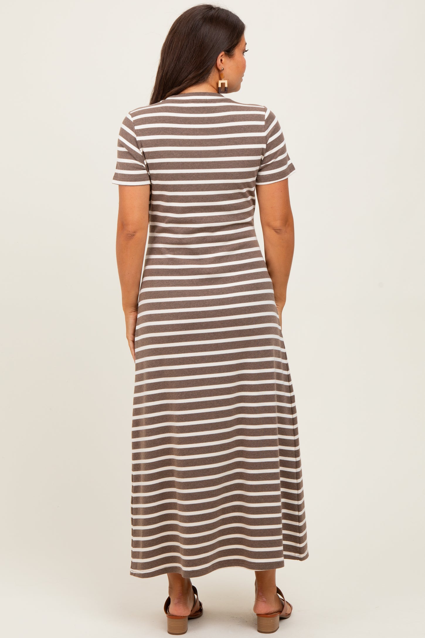 woman wearing a brown and white striped maternity maxi dress, view from the back