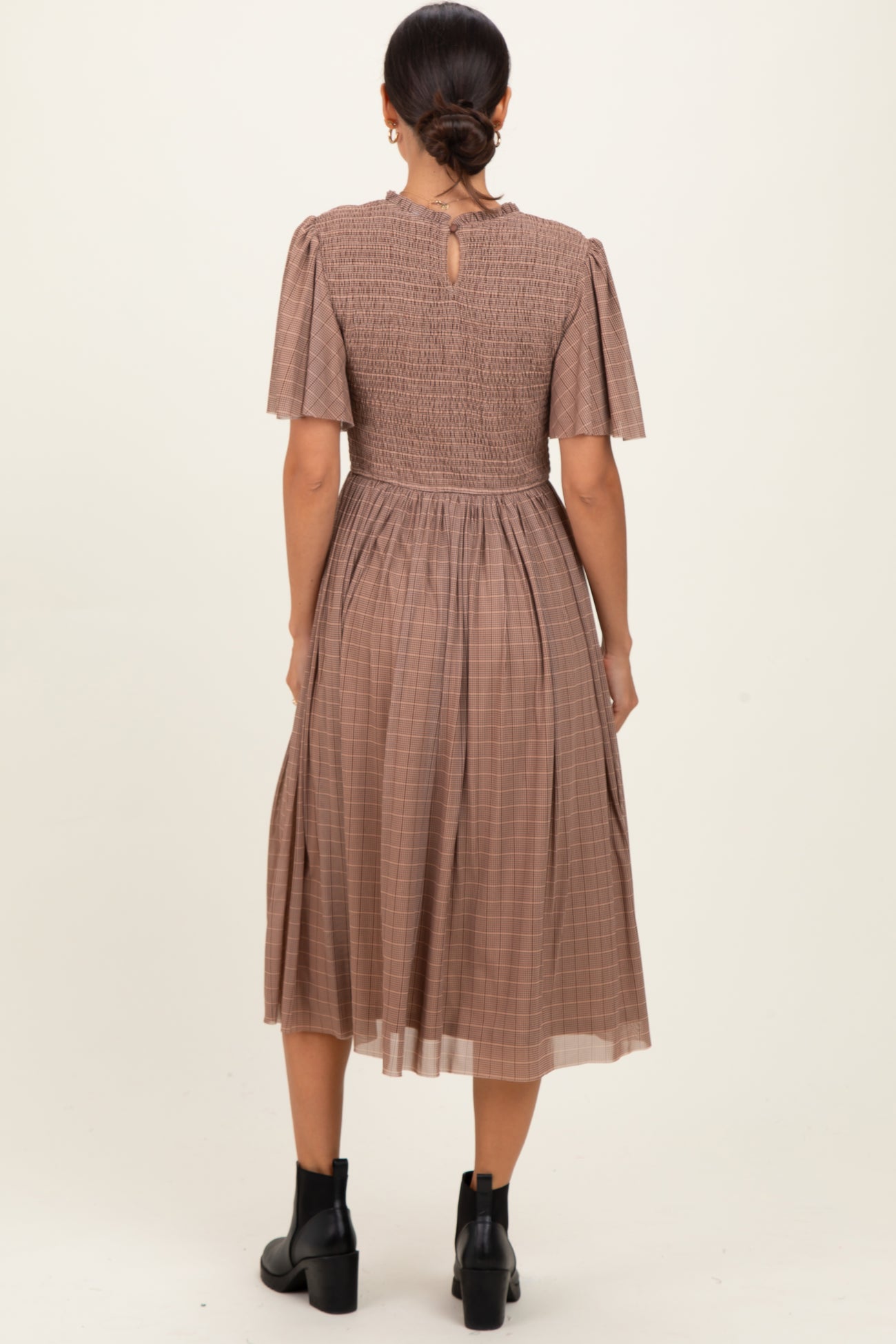 woman wearing a brown checkered midi dress with short puff sleeves and a smocked back detail