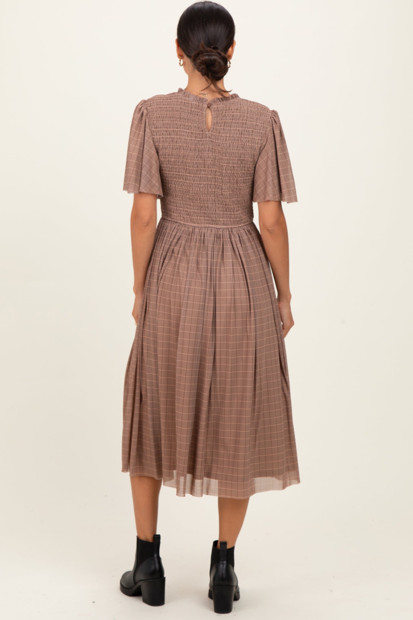 woman wearing a brown checkered midi dress with short puff sleeves and a smocked back detail