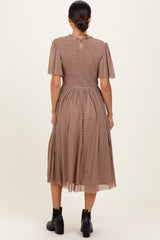 woman wearing a brown checkered midi dress with short puff sleeves and a smocked back detail