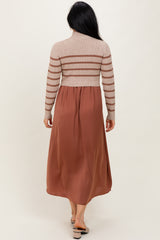 woman wearing a beige striped long sleeve sweater top with a rust colored maxi dress, viewed from the back
