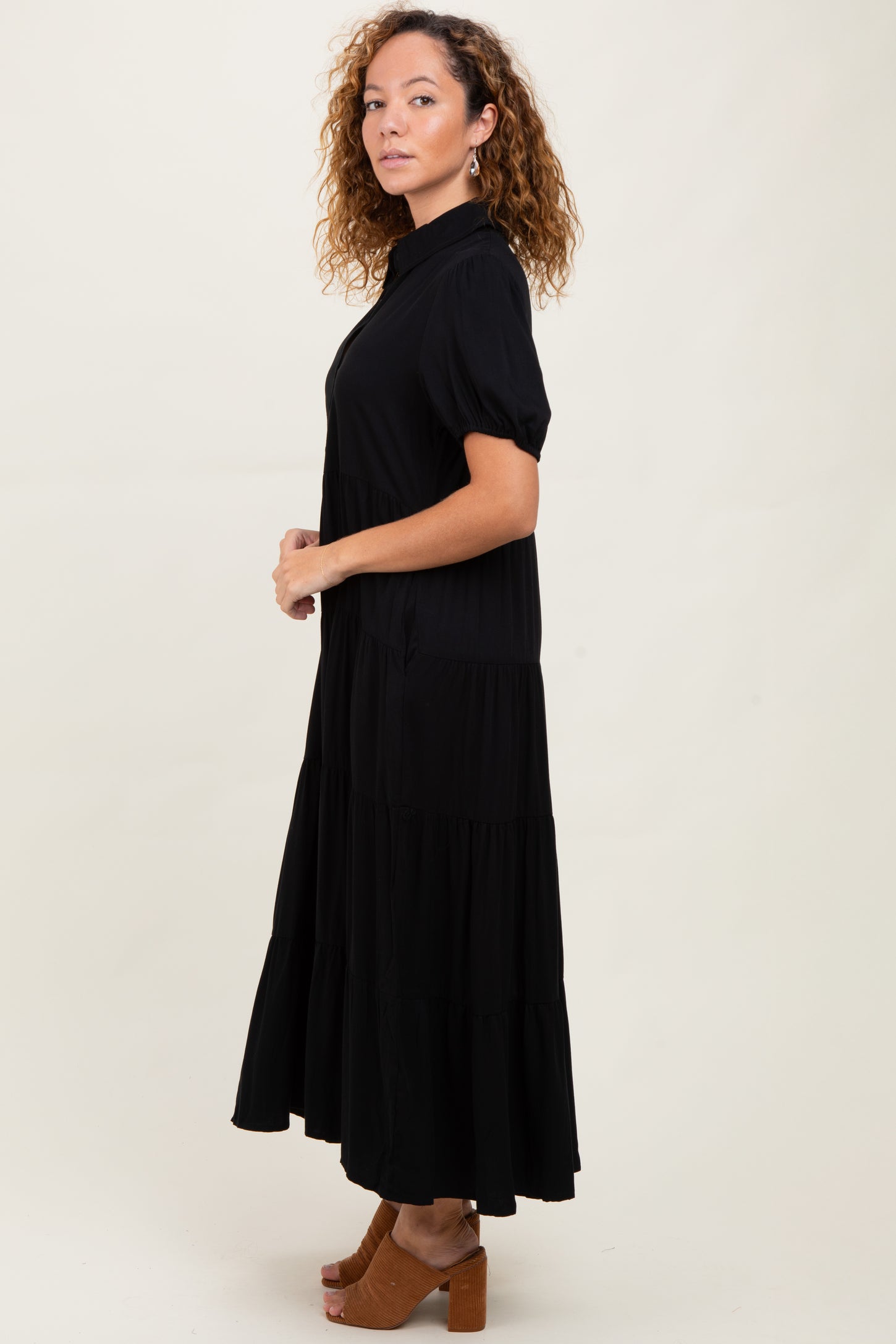 woman wearing a black tiered maxi dress with short sleeves and a collar