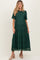 woman wearing a dark green lace short sleeve maternity dress with a flowing skirt and a fitted bodice