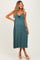 woman wearing a dark teal maternity dress with a front knot and a visible baby bump