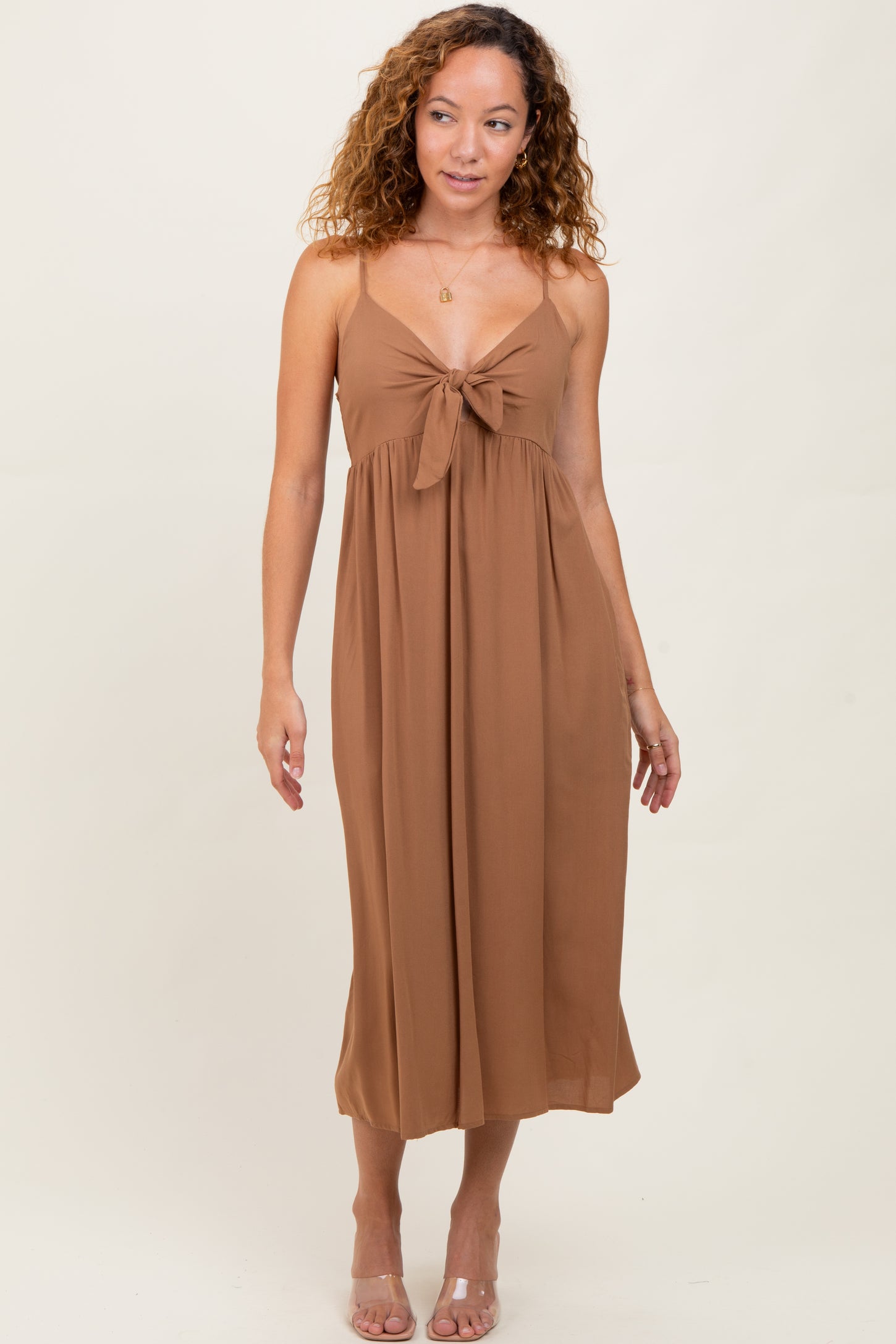 woman wearing a brown midi dress with a knotted front detail and spaghetti straps