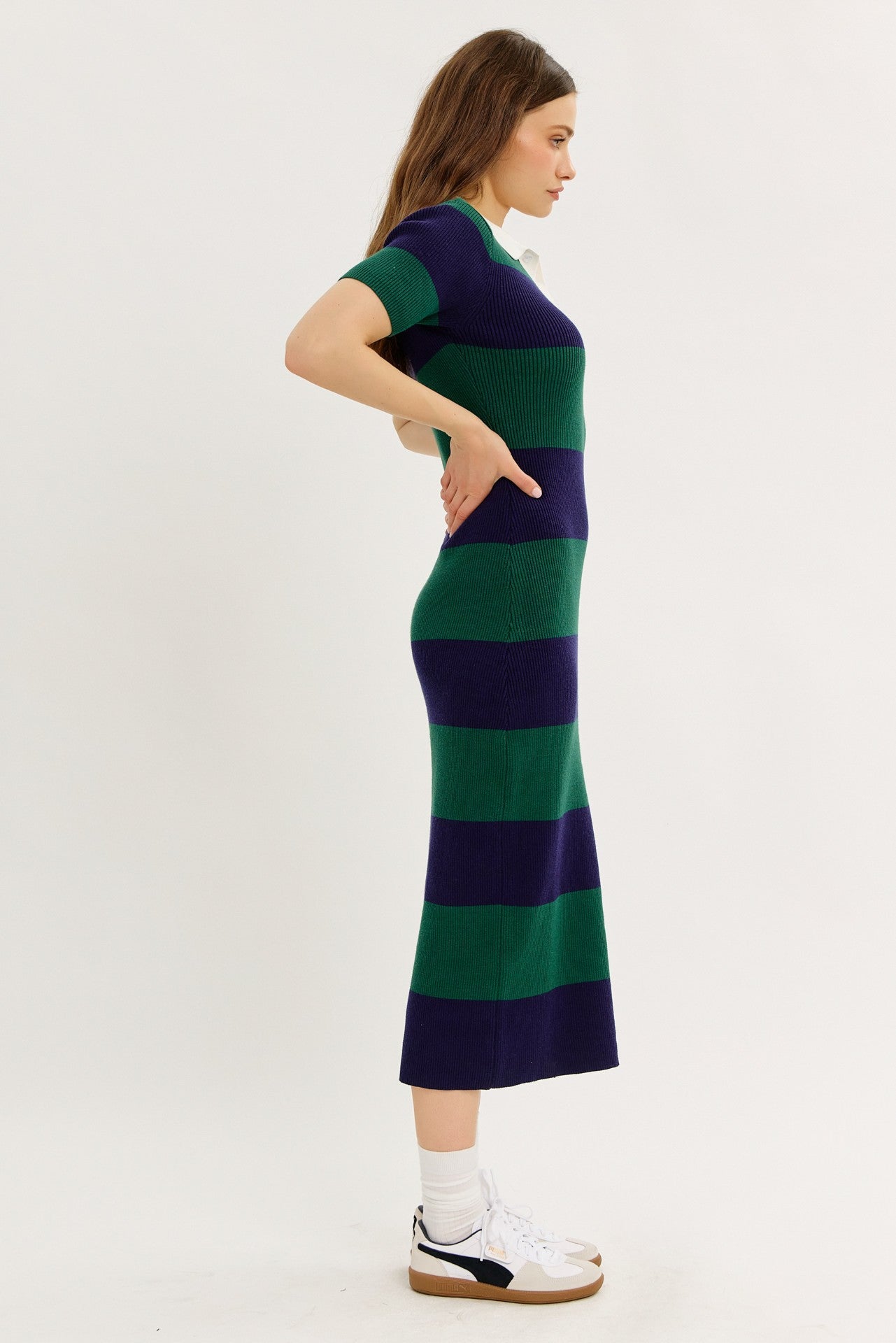woman wearing a navy and green striped midi dress with short sleeves and a fitted silhouette