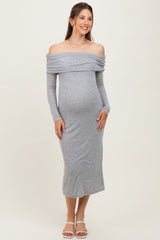 woman wearing a grey off-shoulder maternity dress with long sleeves and a visible baby bump