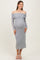 woman wearing a grey off-shoulder maternity dress with long sleeves and a visible baby bump