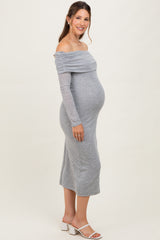 woman wearing a gray off-the-shoulder maternity dress, showcasing her baby bump, standing against a neutral background