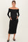 woman wearing a black off-the-shoulder maternity dress, holding her baby bump with a fitted silhouette
