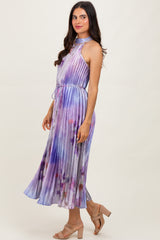 woman wearing a sleeveless purple and blue tie-dye maxi dress with a halter neck and a flowy skirt