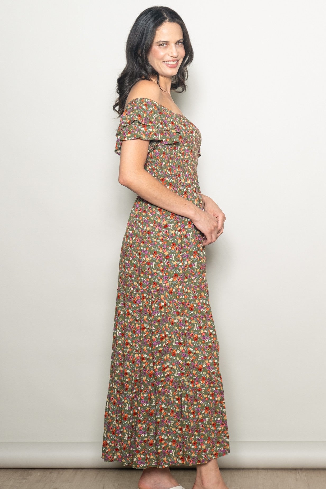 woman wearing a brown floral off-the-shoulder maxi dress with ruffled sleeves and a fitted bodice
