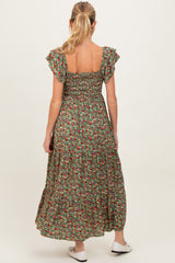 woman wearing a green floral maternity maxi dress with flutter sleeves and a tiered skirt, showing her back