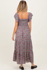 woman wearing a floral print maternity maxi dress with short ruffle sleeves and a smocked bodice