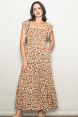 woman wearing a floral maxi dress with short ruffled sleeves and a square neckline