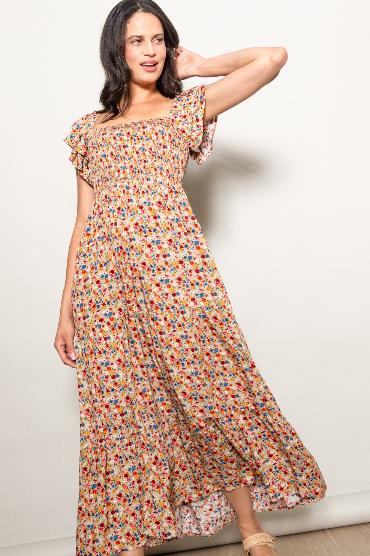 woman wearing a floral print maxi dress with short flutter sleeves and a smocked bodice