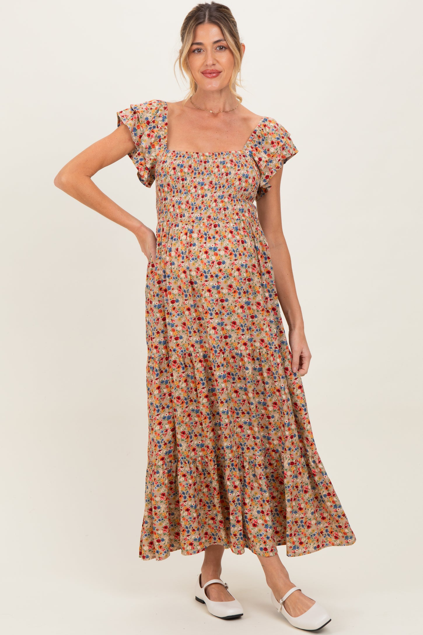 woman wearing a floral print maternity maxi dress with short puff sleeves and a square neckline, showing her baby bump