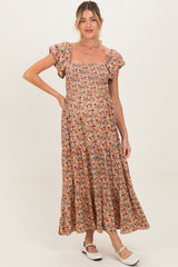 woman wearing a floral print maternity maxi dress with short puff sleeves and a square neckline, showing her baby bump