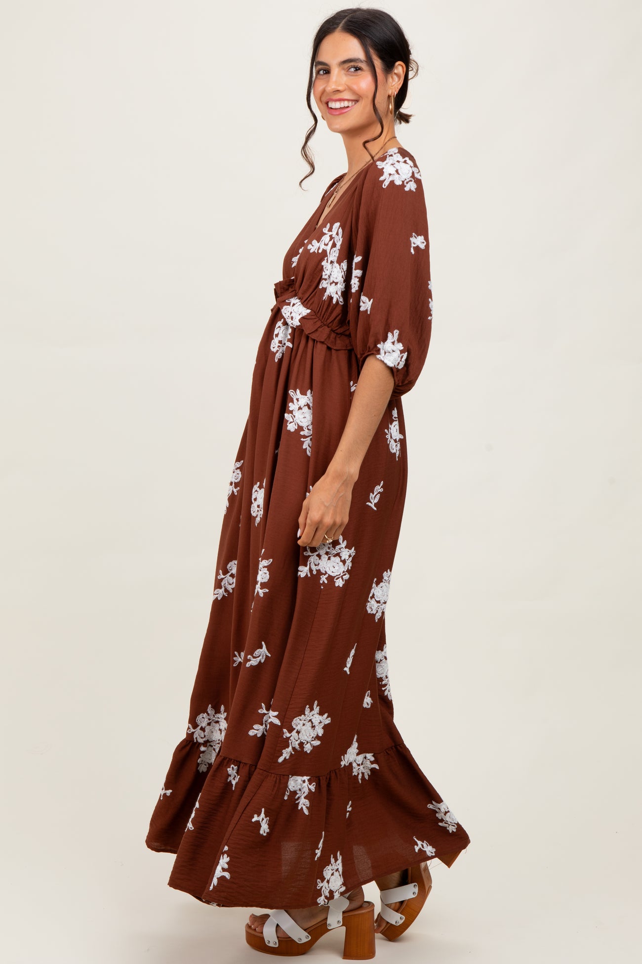 woman wearing a brown floral maxi dress with a gathered waist and puff sleeves