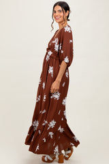 woman wearing a brown floral maxi dress with a gathered waist and puff sleeves
