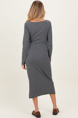 woman wearing a striped gray long sleeve maternity dress, seen from the back