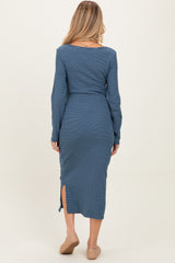 woman wearing a blue striped long sleeve maternity dress with side slits and a fitted silhouette