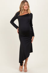 woman wearing a black long sleeve maternity dress with an asymmetrical hem and a visible baby bump